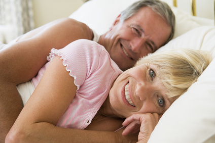 Couple lying in bed smiling